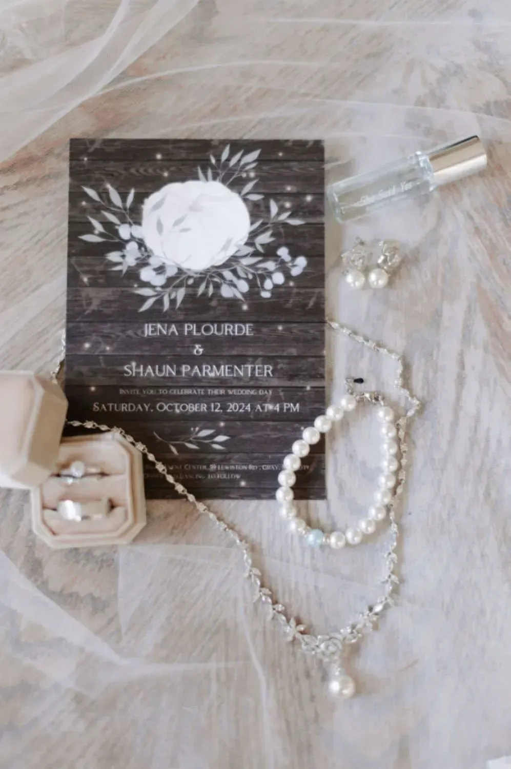 Wedding rings, pearl bracelet, and necklace with the wedding invitation .