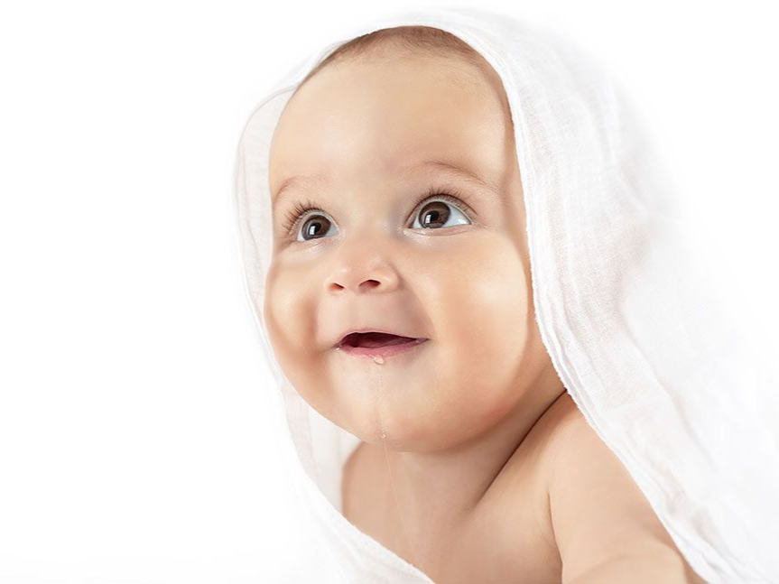 Smiling baby wrapped in a white blanket on a white background
