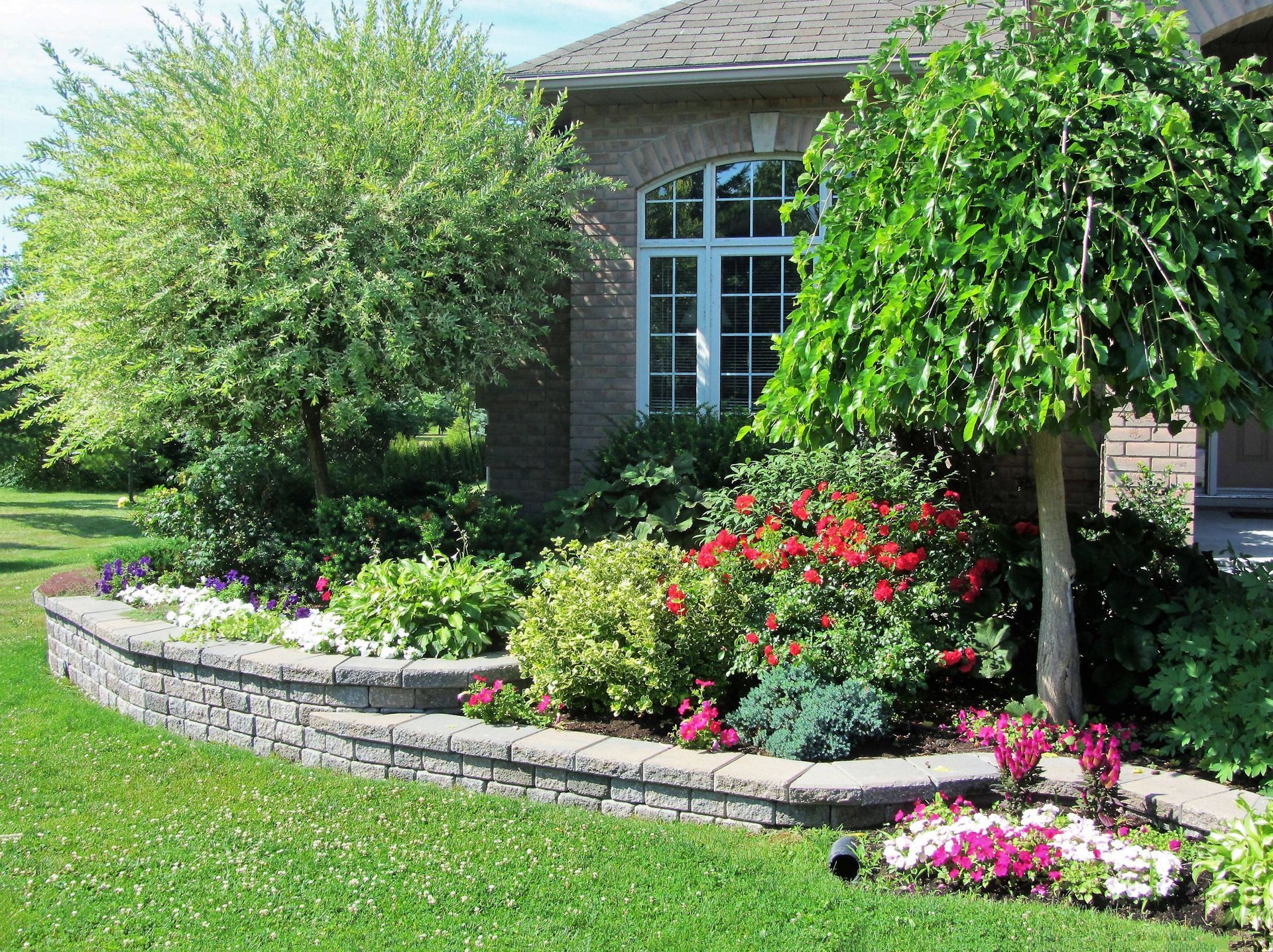 Front landscaping that include mulch, bushes, and landscaping trees.