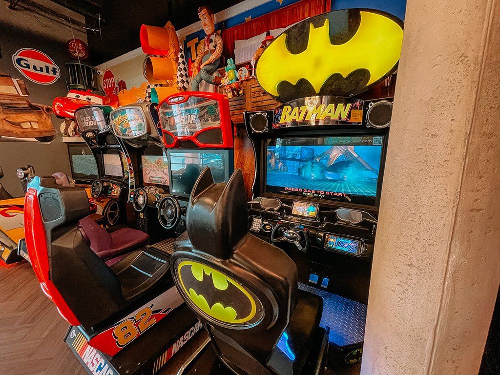 Arcade with Batman game and racing games, colorful setting.