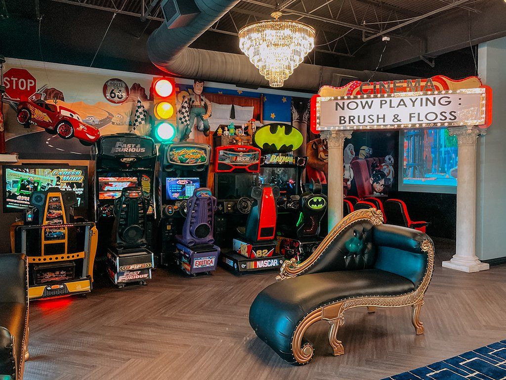 Arcade room with games, chaise lounge, movie sign.