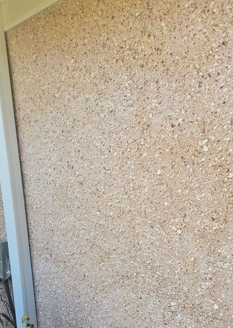 A close up of a wall with a lot of small stones on it.
