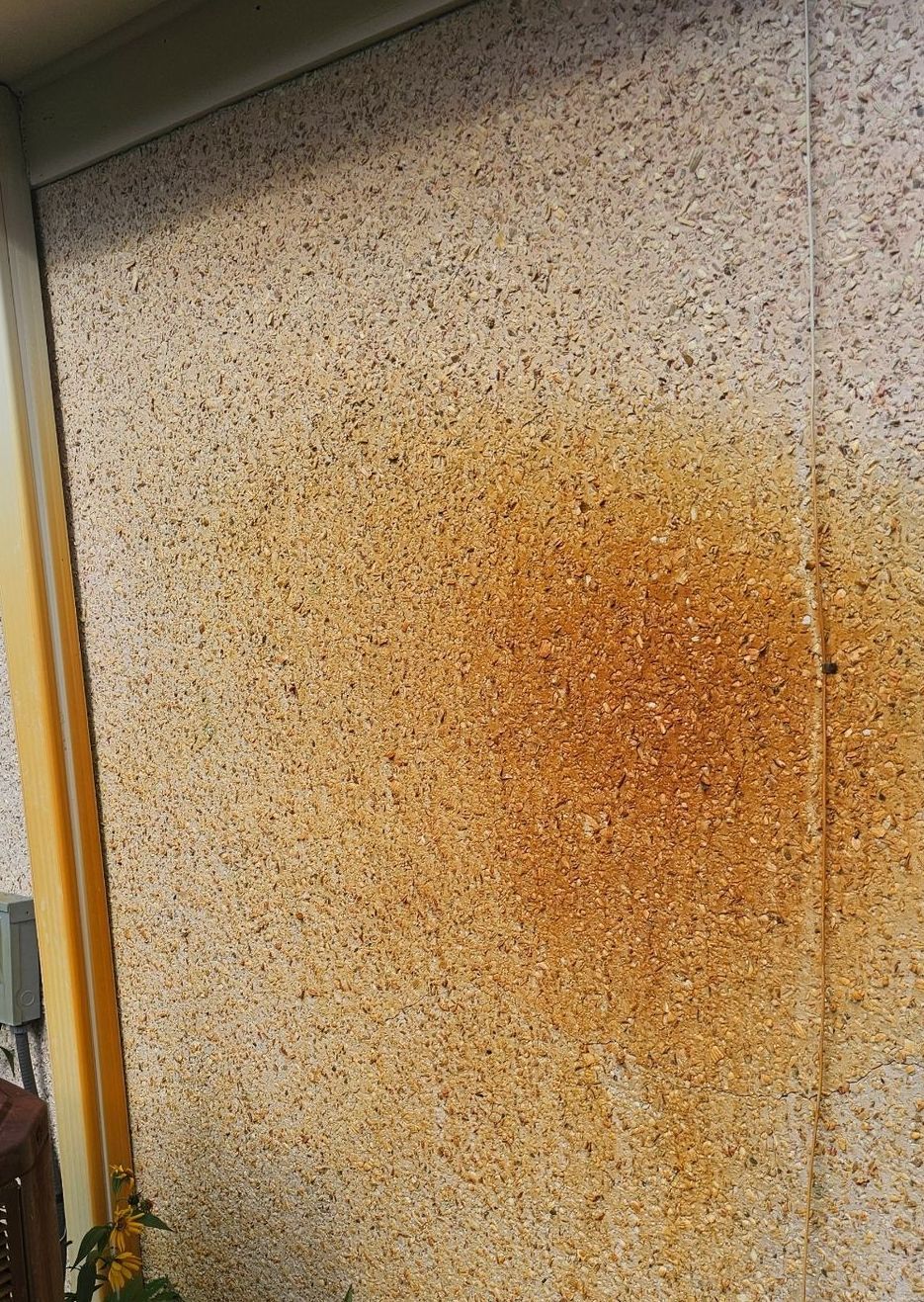 A close up of a wall with a brown stain on it.