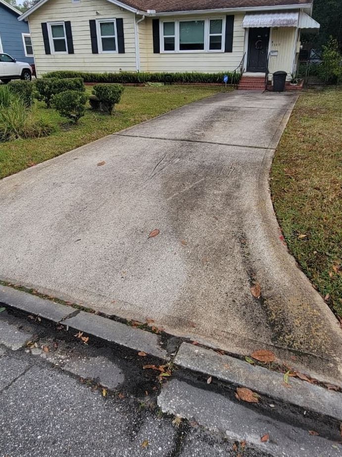 A driveway leading to a house with a car parked in front of it.