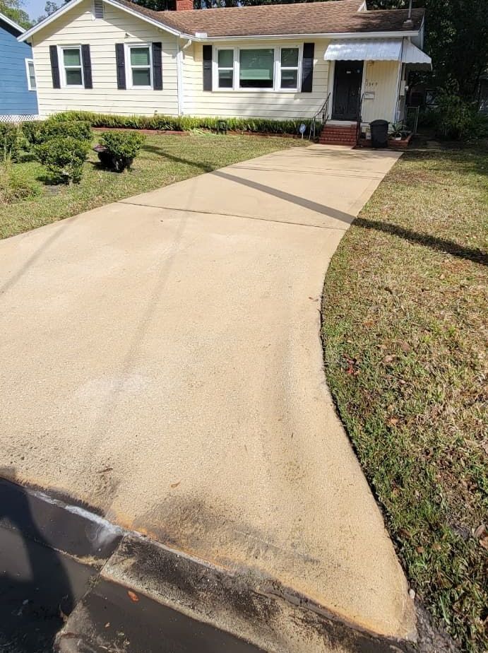 A white house with a driveway leading to it