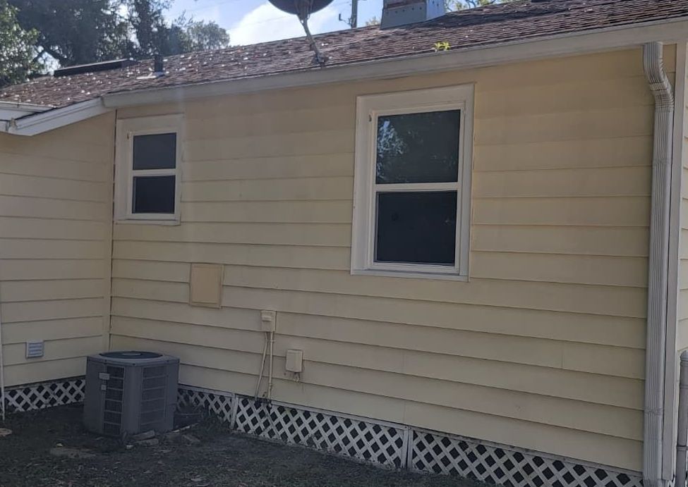 The back of a house with a satellite dish on the roof.