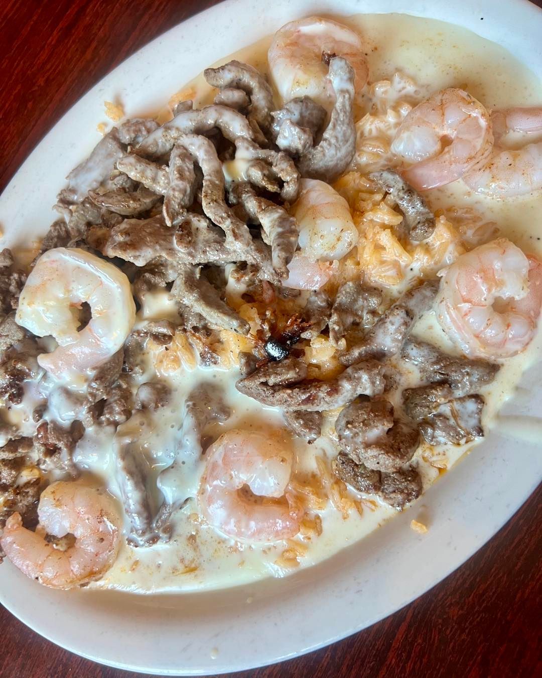 steak and shrimp over rice with queso