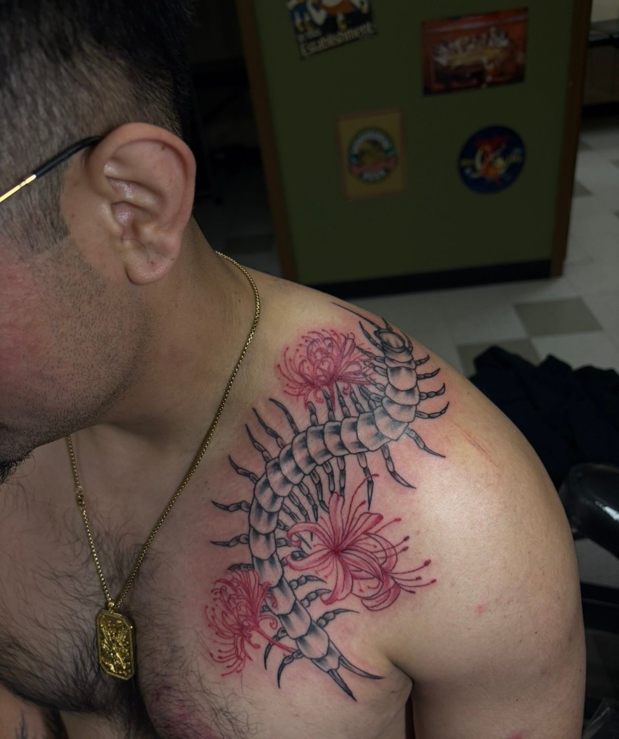 Close-up of a shoulder with a red and black floral tattoo