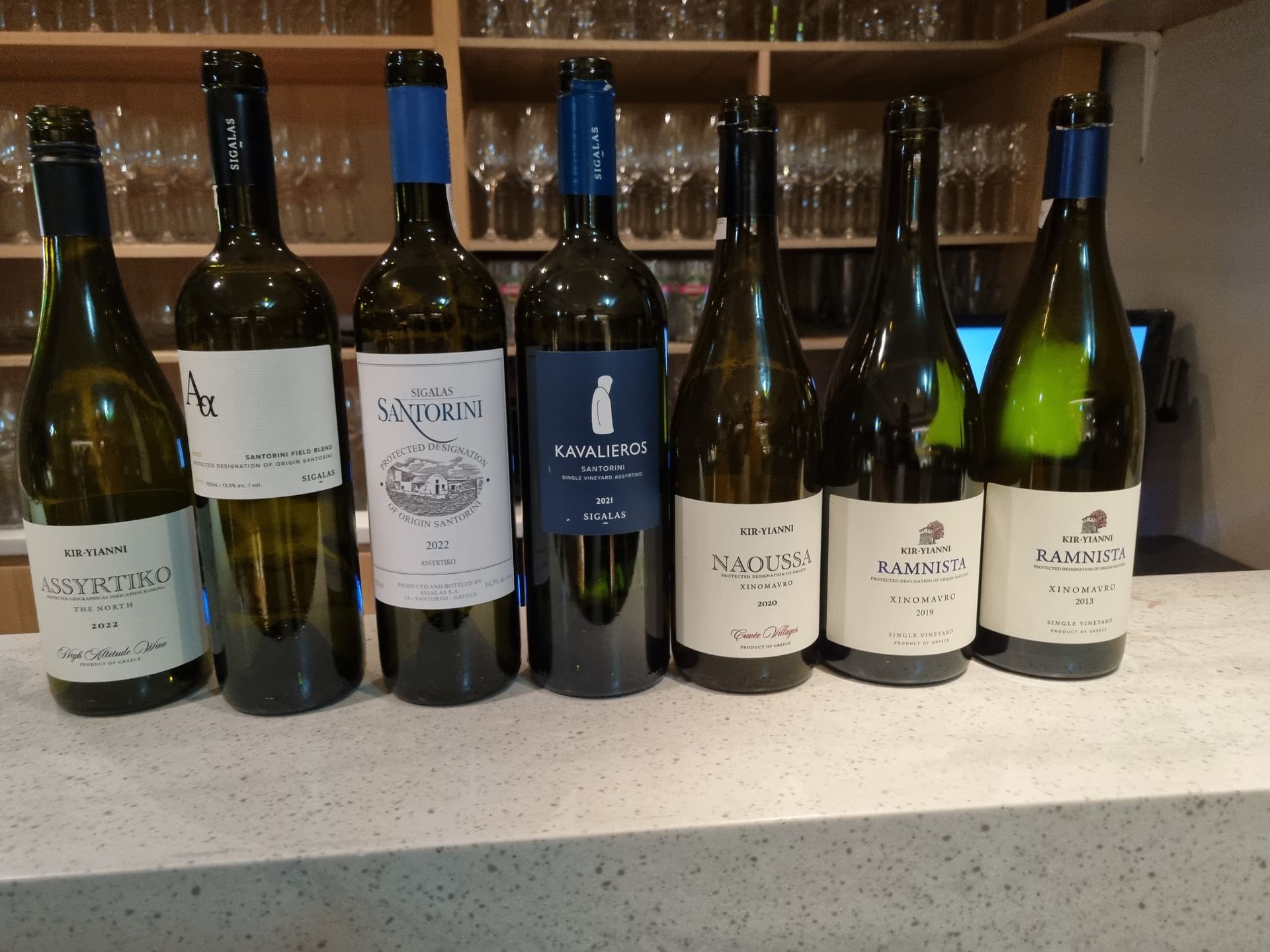 A row of wines atop a bar. Ola, Ta, krasia, 29