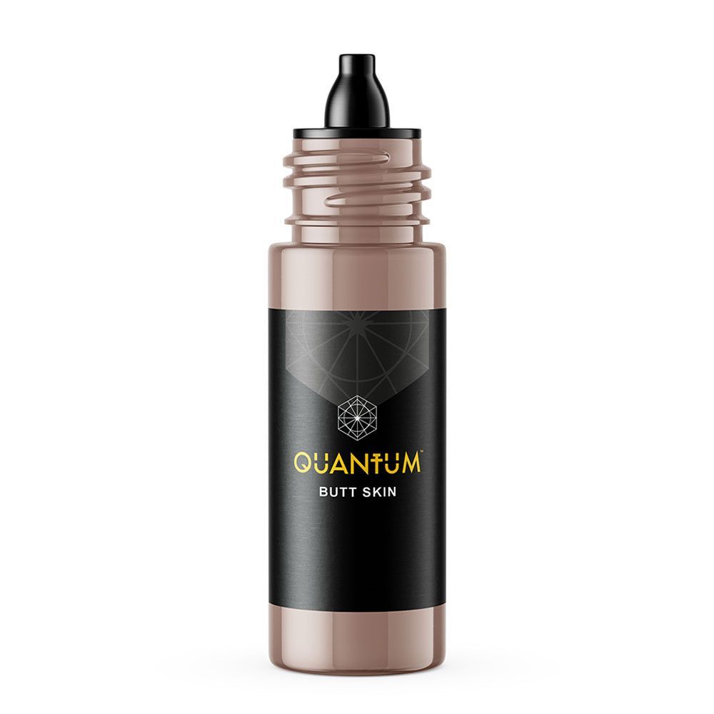 A bottle of Quantum brand tattoo ink, featuring a black label with gold text on a matching light brown background.