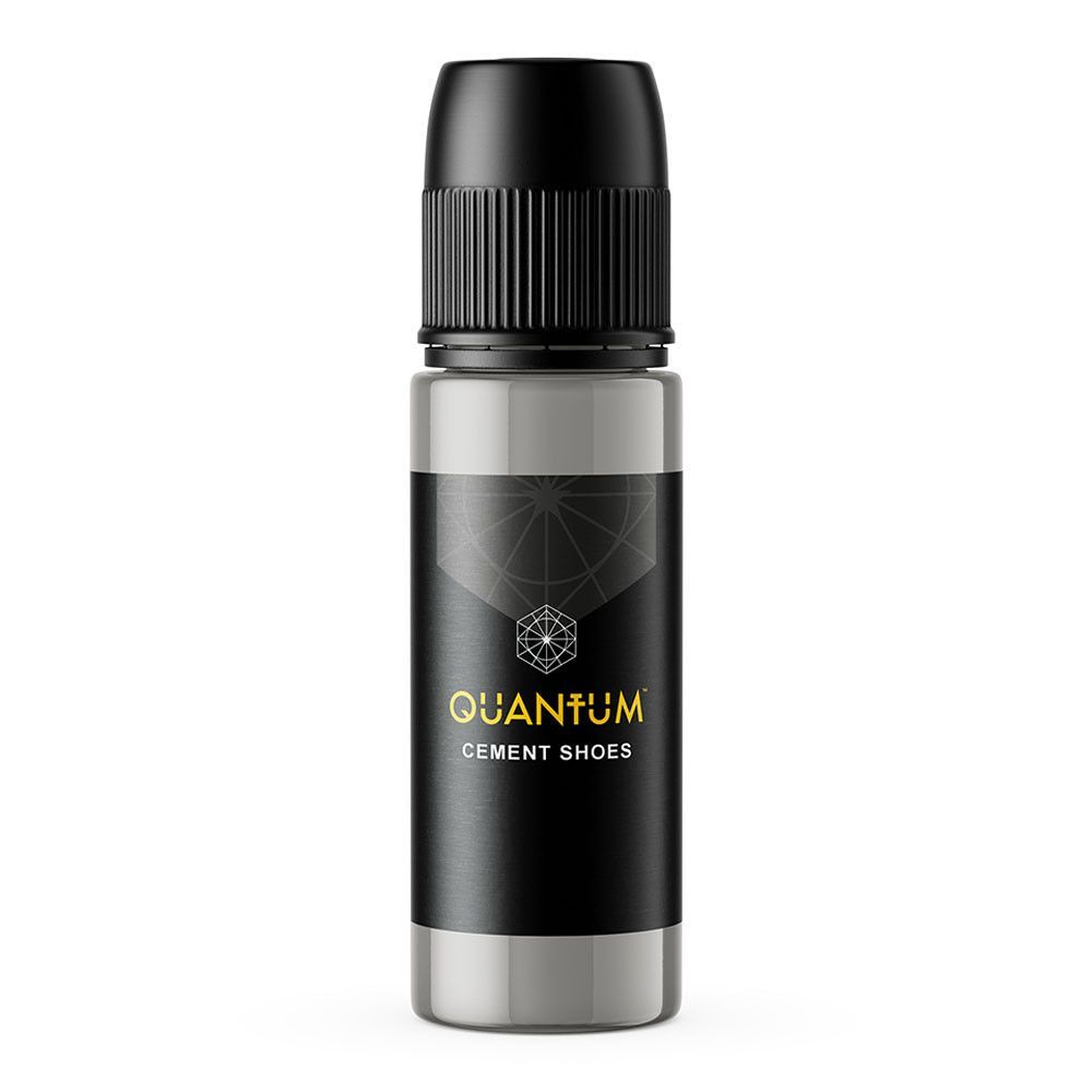 A grey, cylindrical bottle of Quantum Cement Shoes pigment with a black cap and a black label featuring gold text.