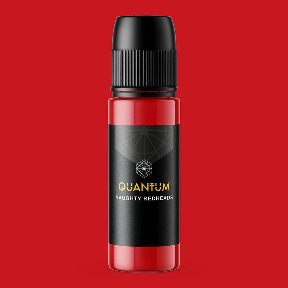 A bottle of Quantum Naughty Redhead tattoo ink with a black label, set against a solid red background.