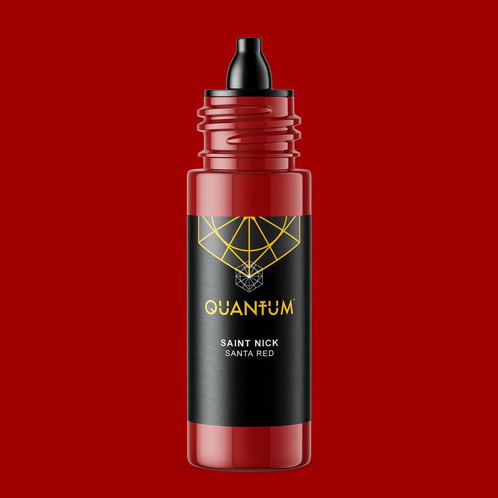 A bottle of Quantum Saint Nick red tattoo ink with a black label, centered against a solid red background.