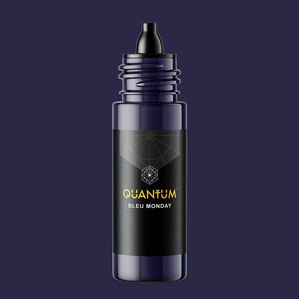 A small, dark blue bottle of Quantum Blue Monday essential oil or fragrance with a black screw-on cap.