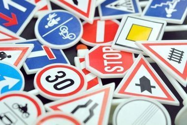 Una pila di segnali stradali colorati tra cui un segnale di stop