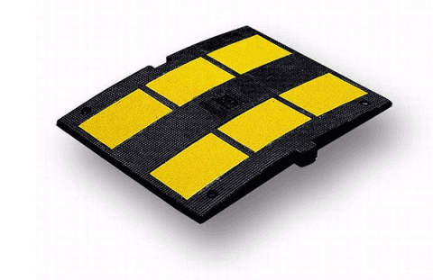 Un dosso rallentatore nero e giallo su uno sfondo bianco