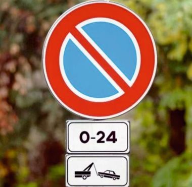 Un cartello di divieto di sosta con scritto 0-24