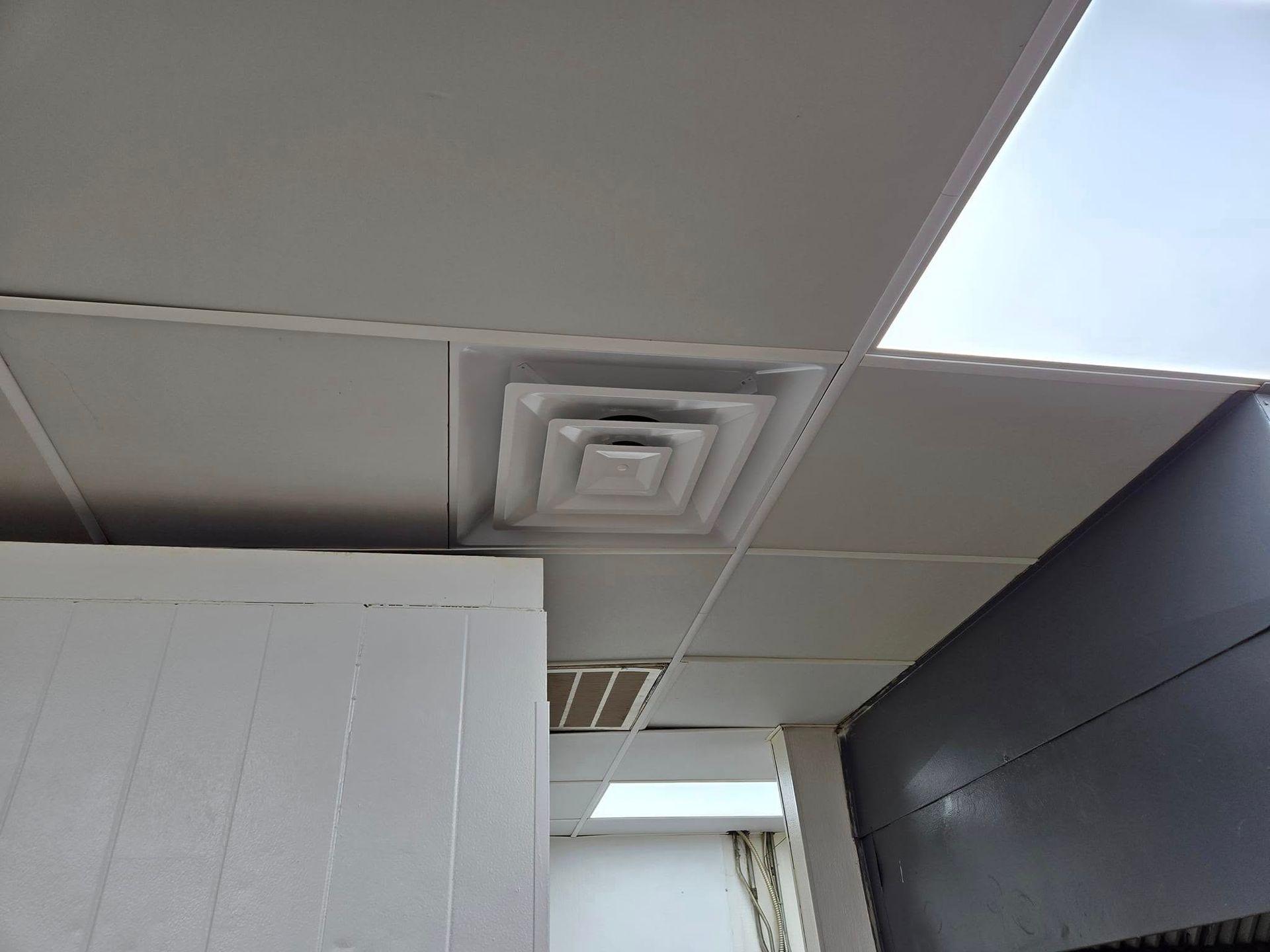 A room with a ceiling that has a ventilation system on it.