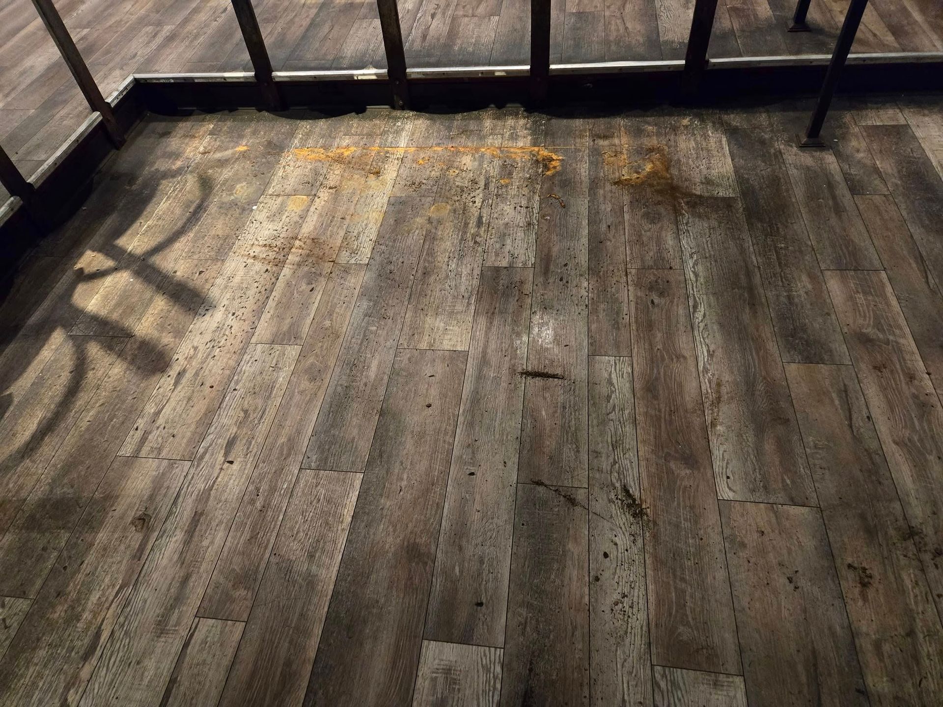 A wooden floor with a lot of stains on it.