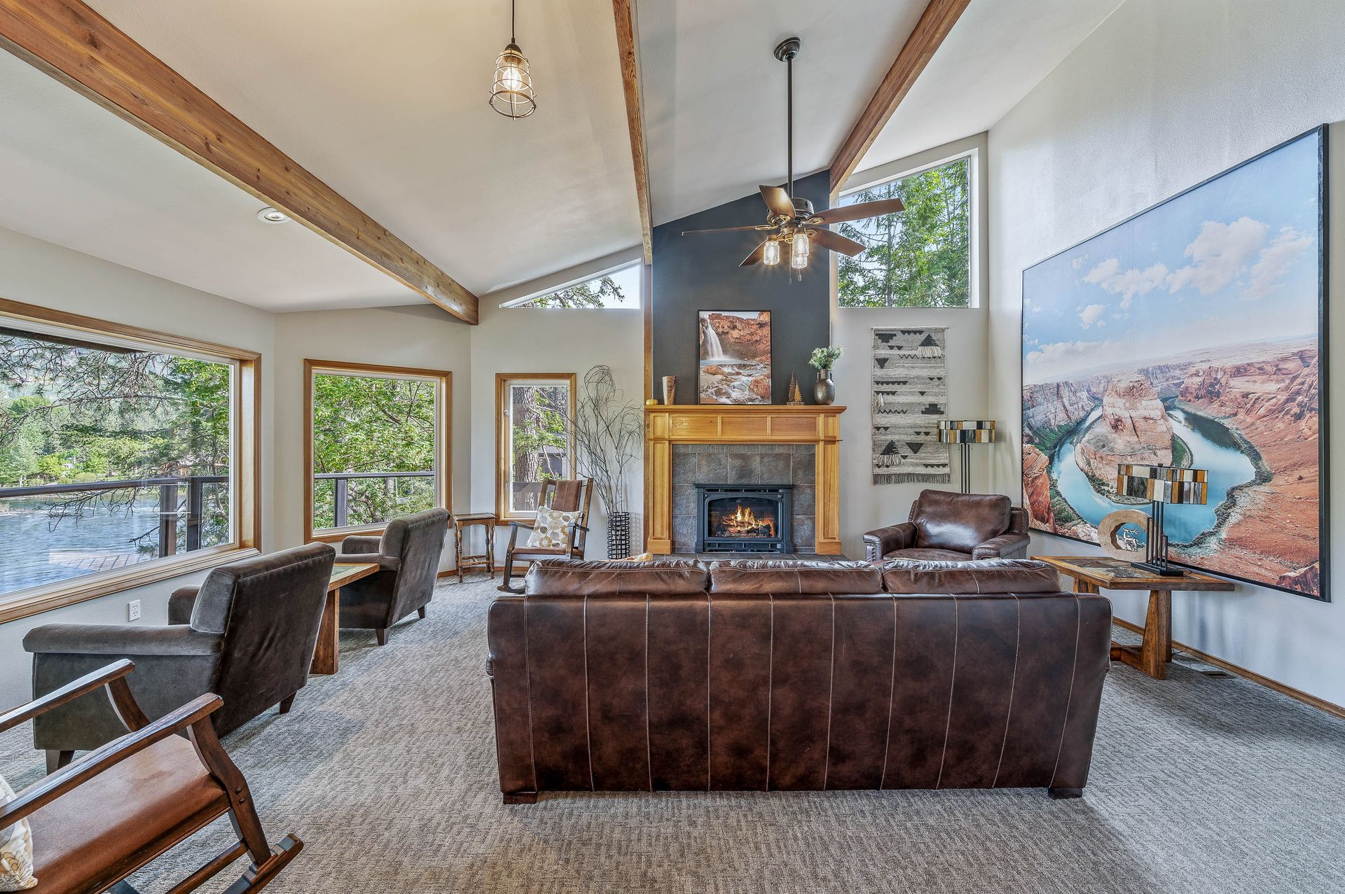 Living room with brown leather sofa, fireplace, and large canyon artwork.