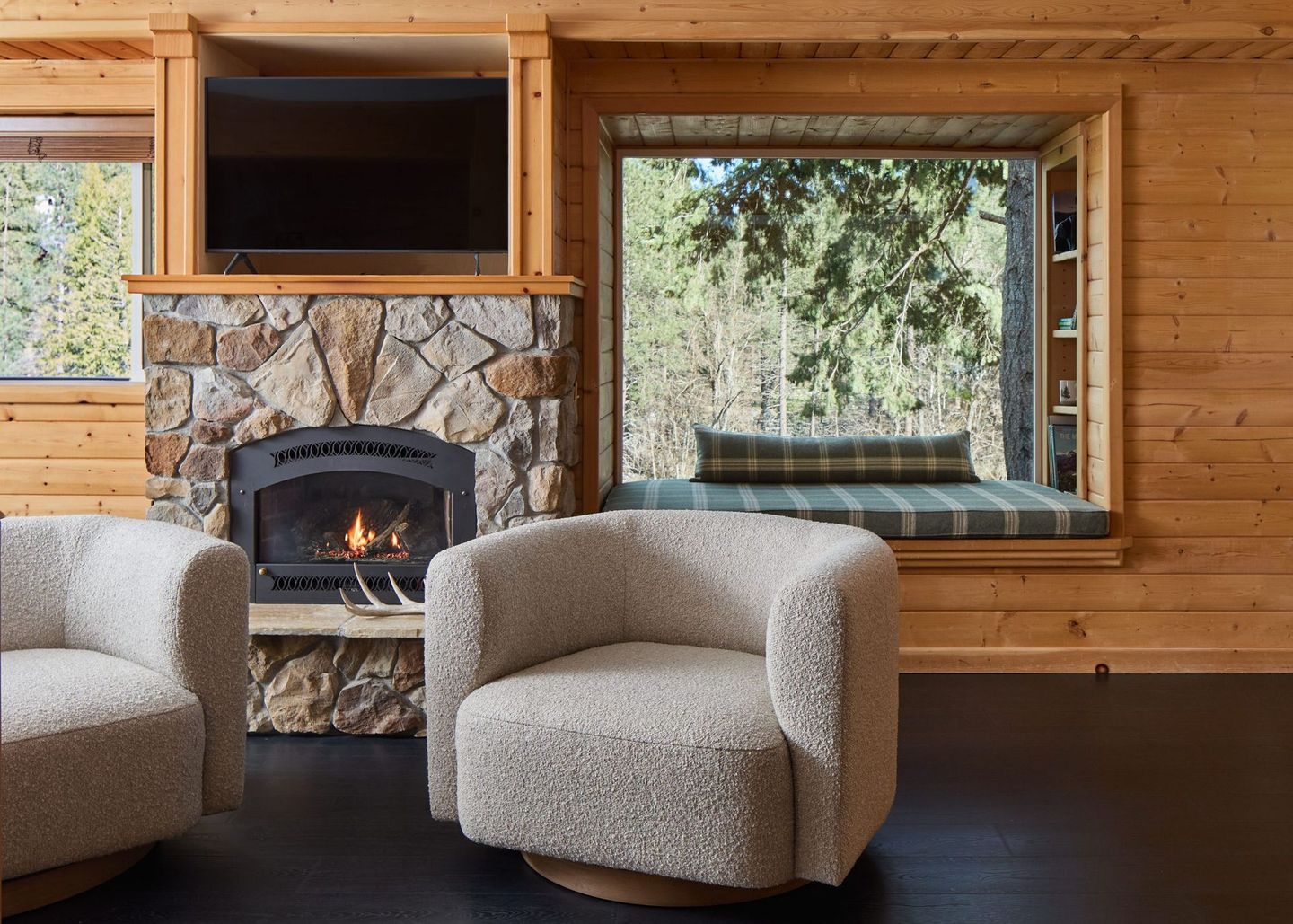 Cozy hotel room in Leavenworth with stone fireplace, large window seat, and two gray chairs
