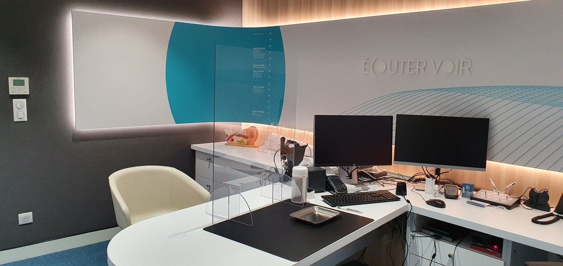 Un bureau avec deux écrans d'ordinateur dessus dans un bureau.