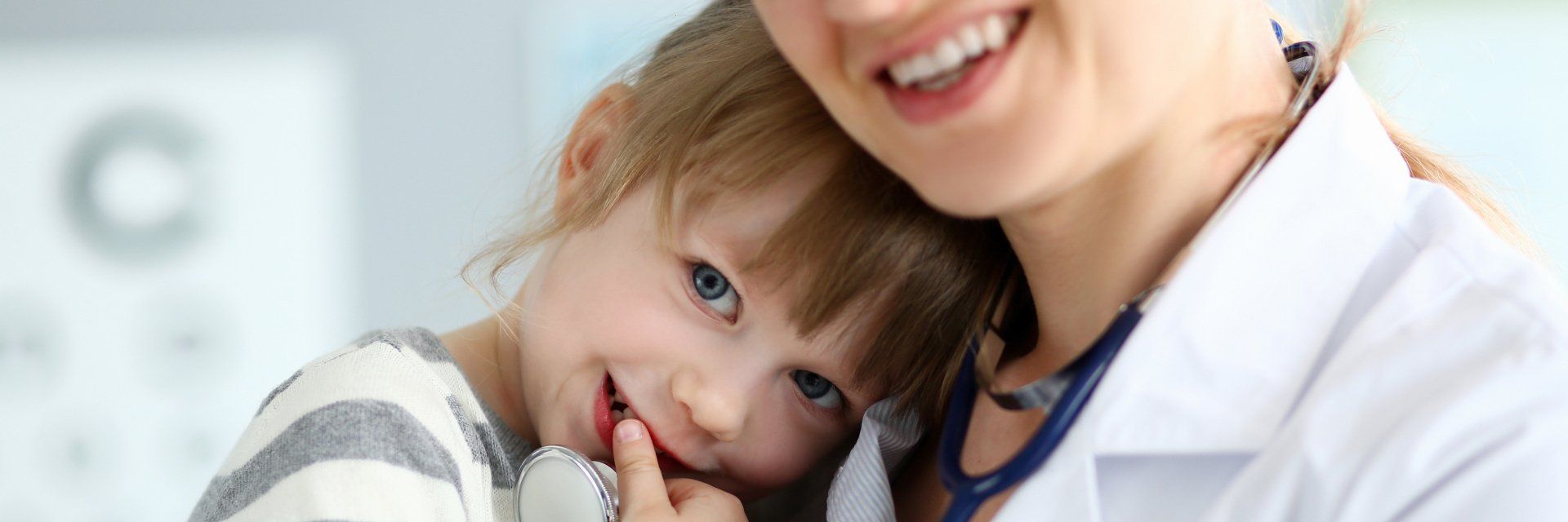 Un médecin tient une petite fille dans ses bras.