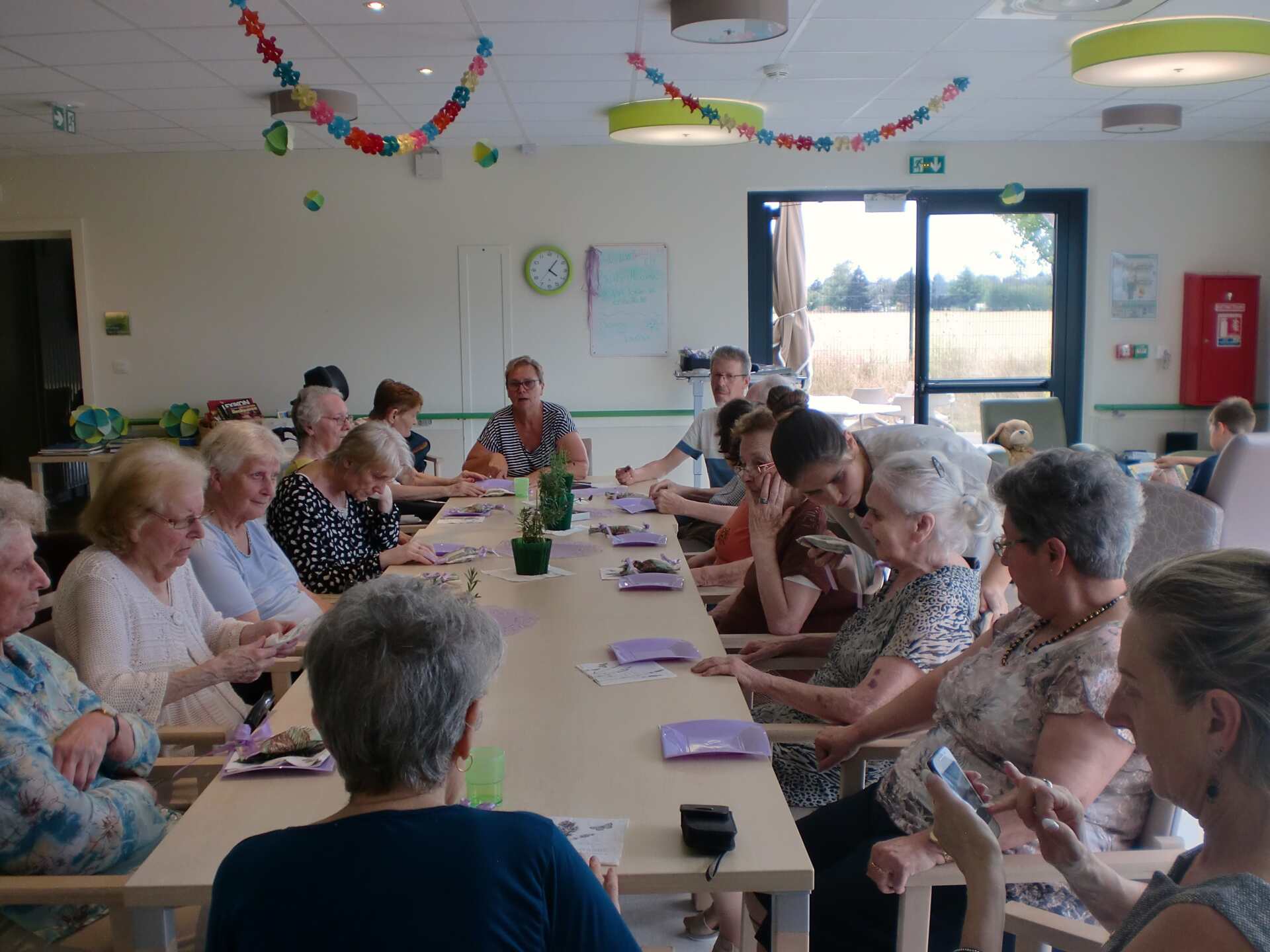 Un groupe de personnes sont assises à de longues tables dans une pièce.