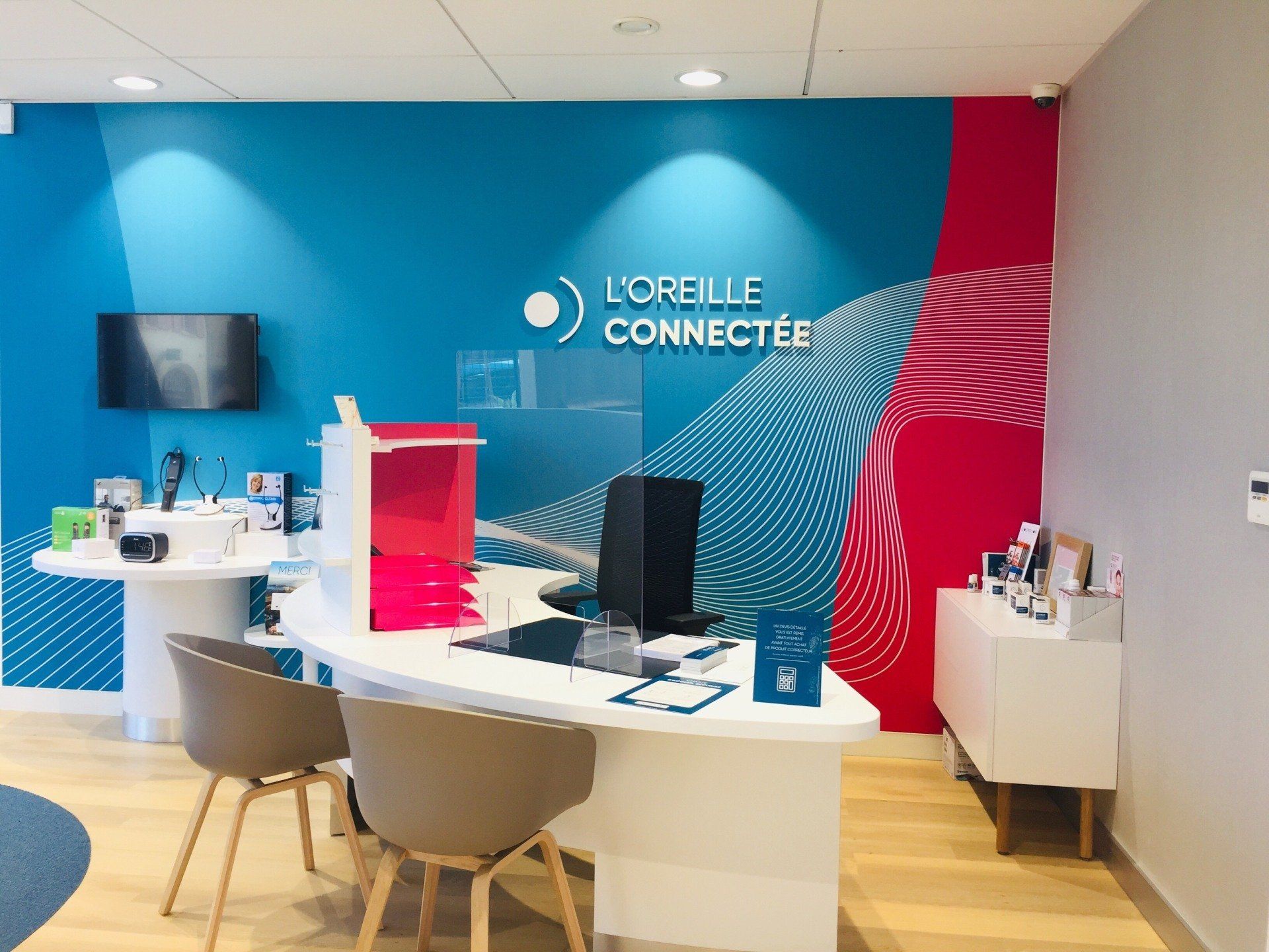 Une pièce avec un bureau et des chaises et un mur sur lequel est écrit l'oreille connectée
