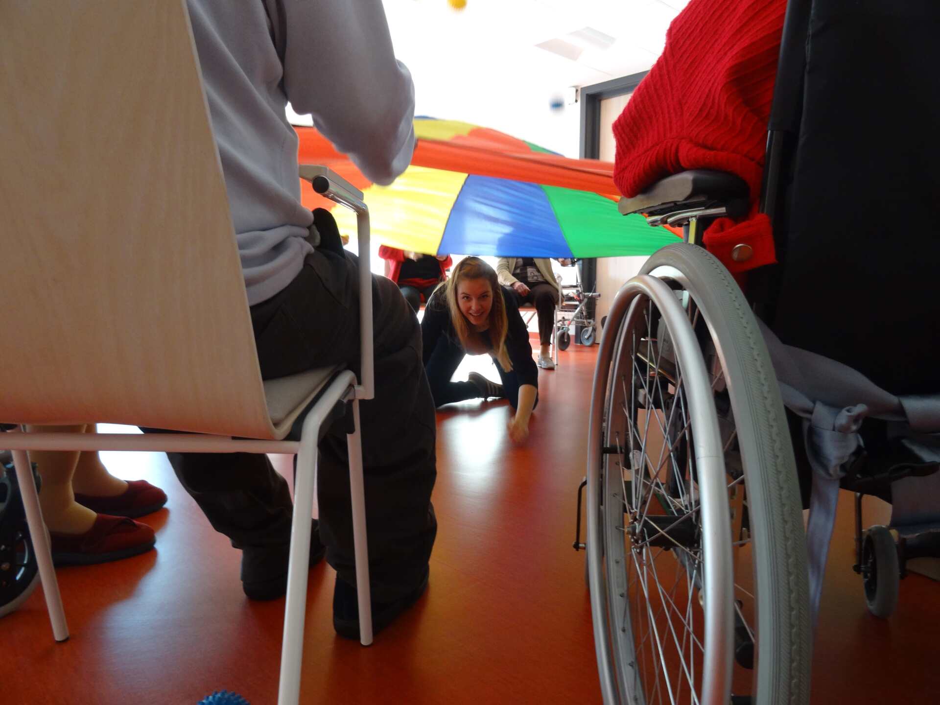 Une femme en fauteuil roulant joue avec un parachute coloré