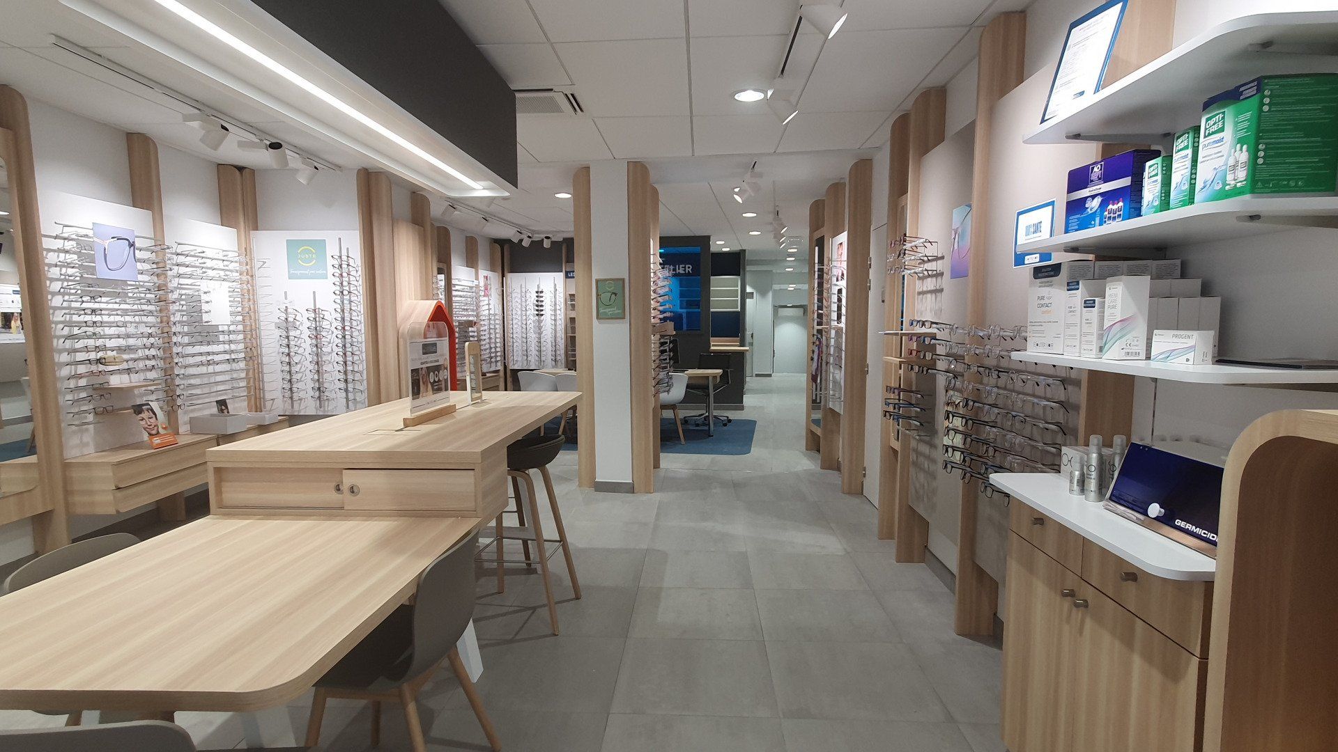 Un long couloir dans un magasin d'optique avec des tables et des étagères.
