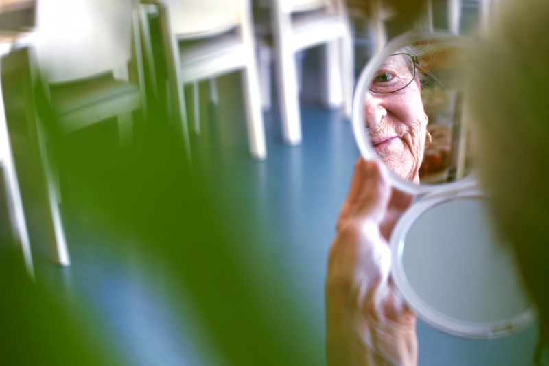 Une femme regarde son reflet dans un miroir.