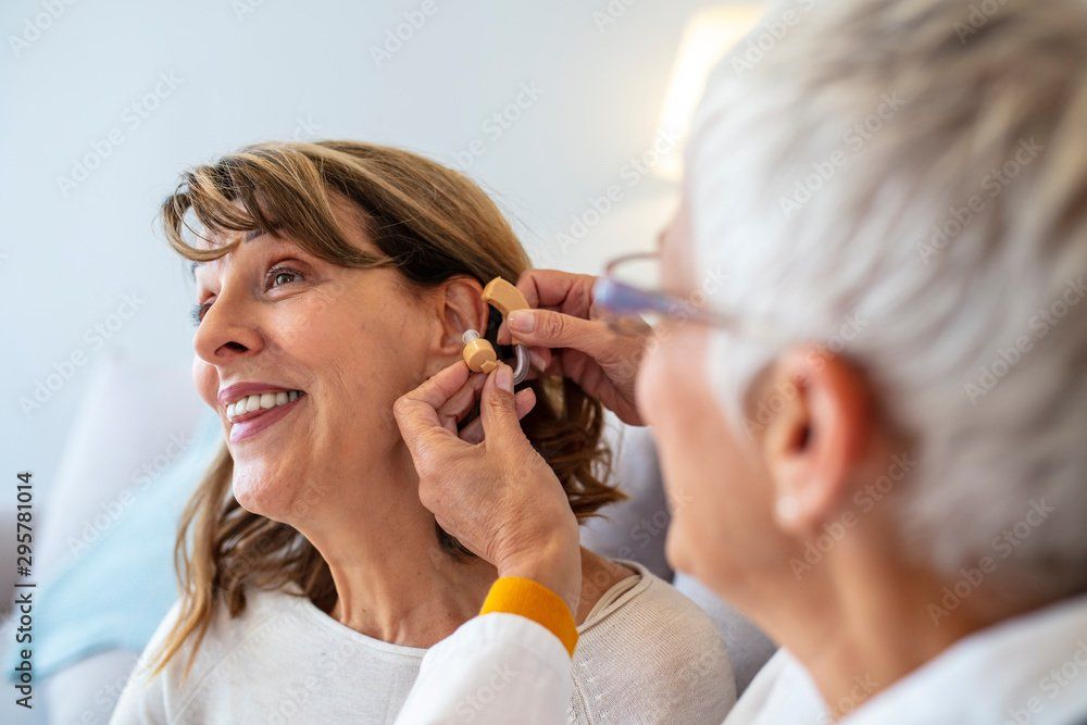Une femme reçoit un appareil auditif d'un médecin.