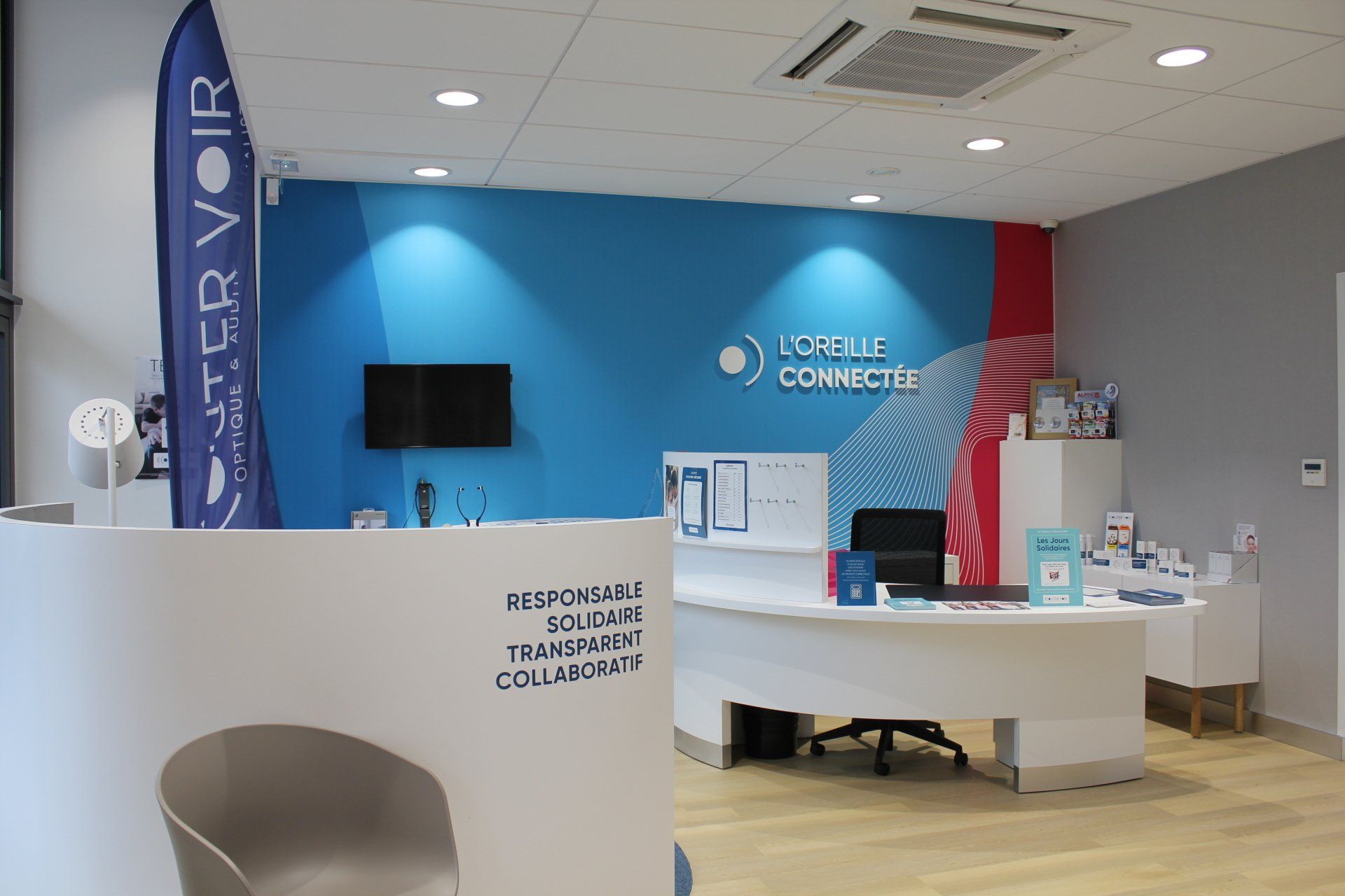 Un espace de réception avec un mur bleu et un bureau blanc.