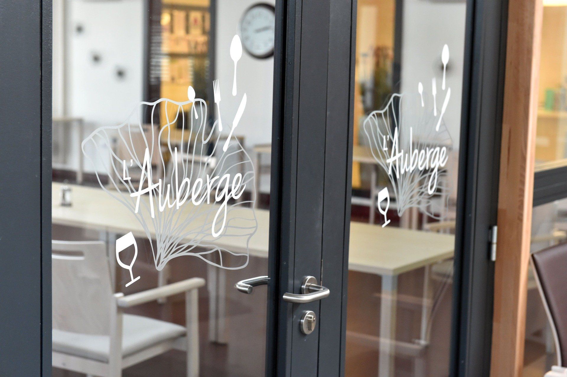 Une porte vitrée avec le mot auberge écrit dessus.