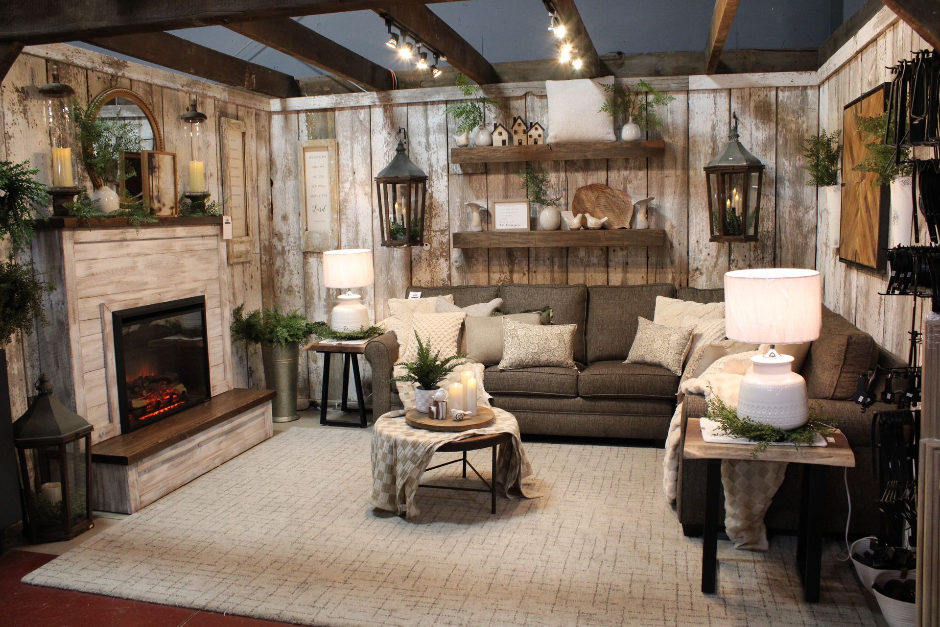 Cozy living room with rustic wood paneling, featuring a sofa, coffee table, and decorative wreaths.