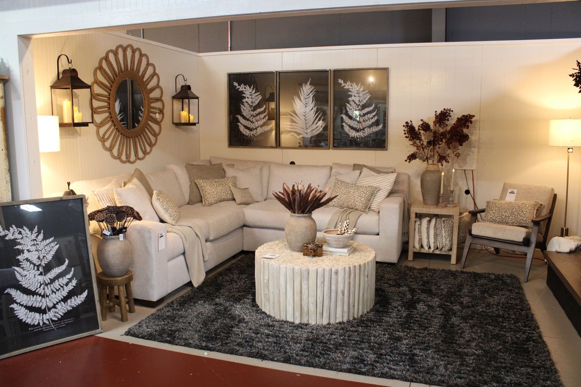 Cozy living room with brown sectional, wood coffee table, and decorative wall art. Warm lighting and neutral tones.