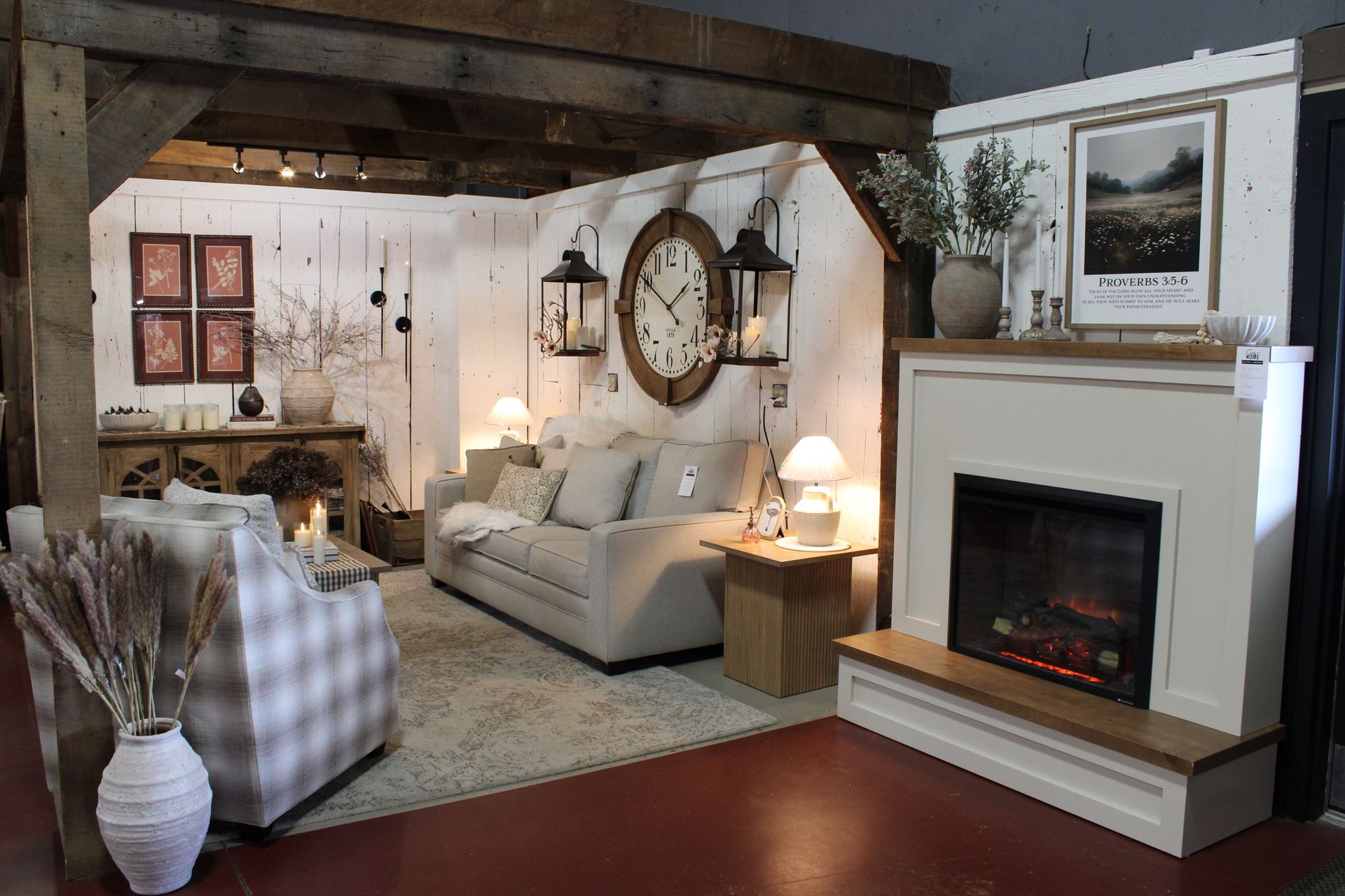 Cozy living room with beige sofa, fireplace, rustic beams, wall decor, and soft lamps