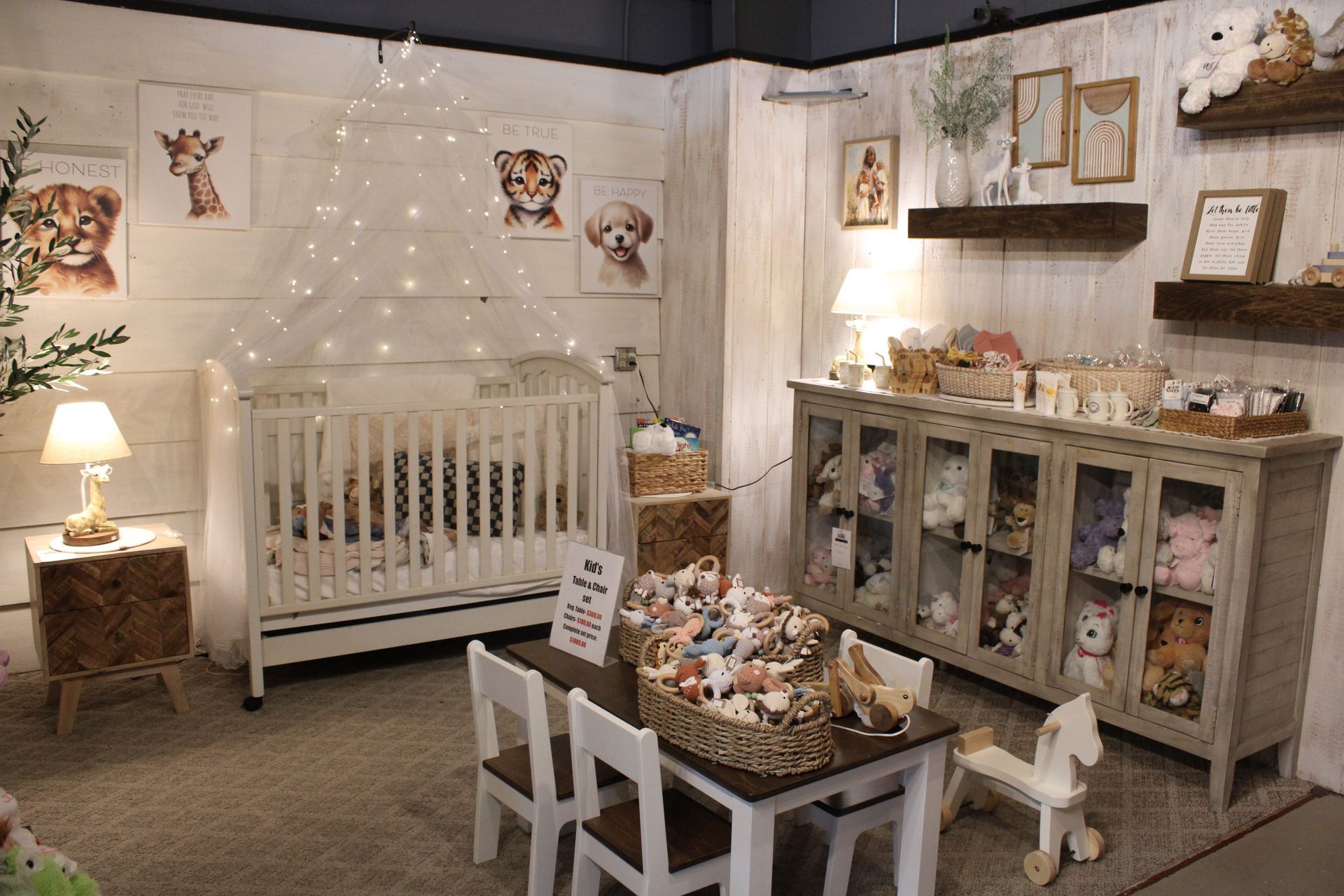 Baby nursery with crib, play tent, wooden dresser, and decorative shelves.