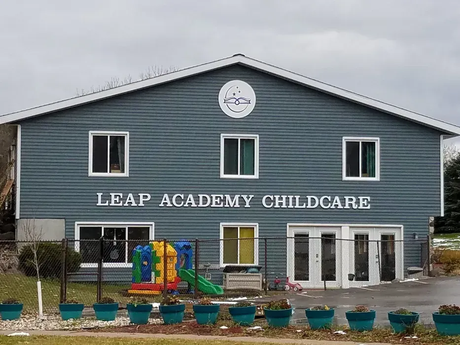 Leap Academy Childcare building with blue siding and playground equipment in front