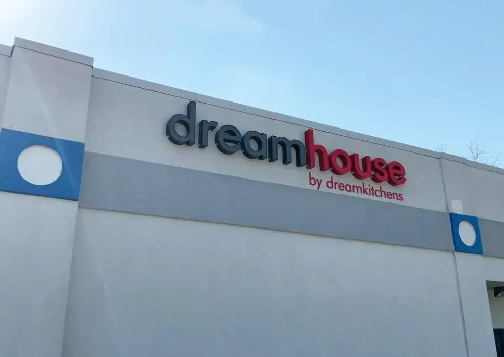 Dreamhouse by DreamWorks storefront sign on a white building under a blue sky