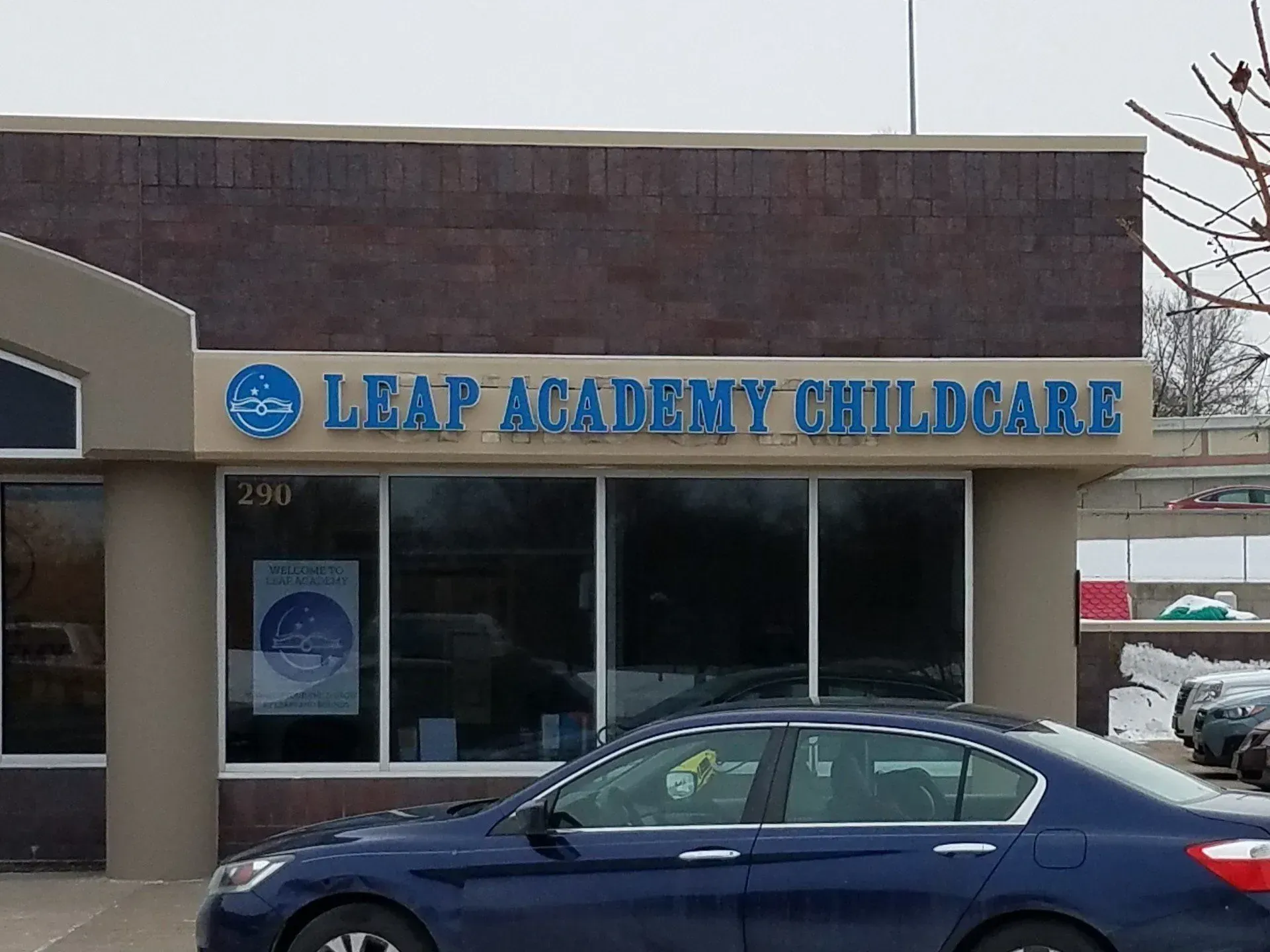 LEAP Academy Childcare storefront with a blue car parked in front