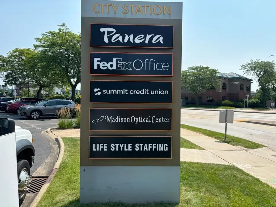 Shopping center directory sign listing Panera, FedEx Office, Summit Credit Union, and other businesses.
