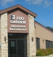 Front entrance of Edo Garden Japanese Restaurant with stone facade and tan exterior under a blue sky