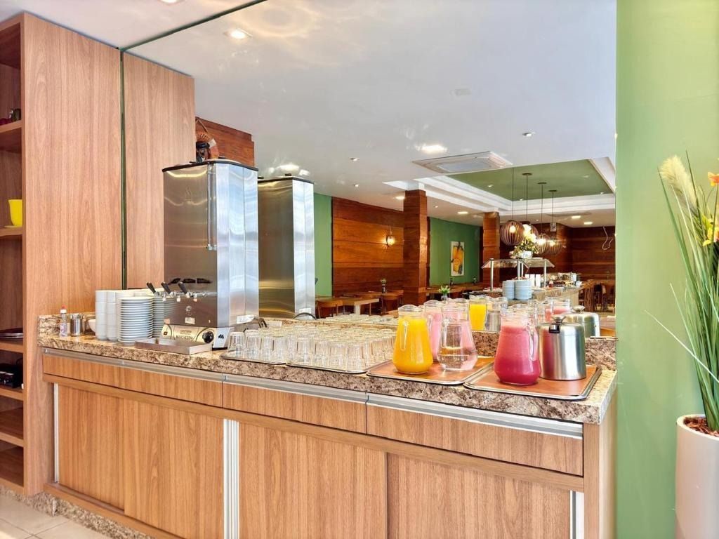 Buffet de cozinha moderna com bancada de granito, armários de madeira e jarras de suco coloridas