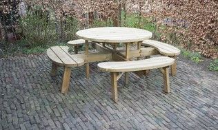 Houten picknicktafel met aangebouwde banken op een stenen terras.