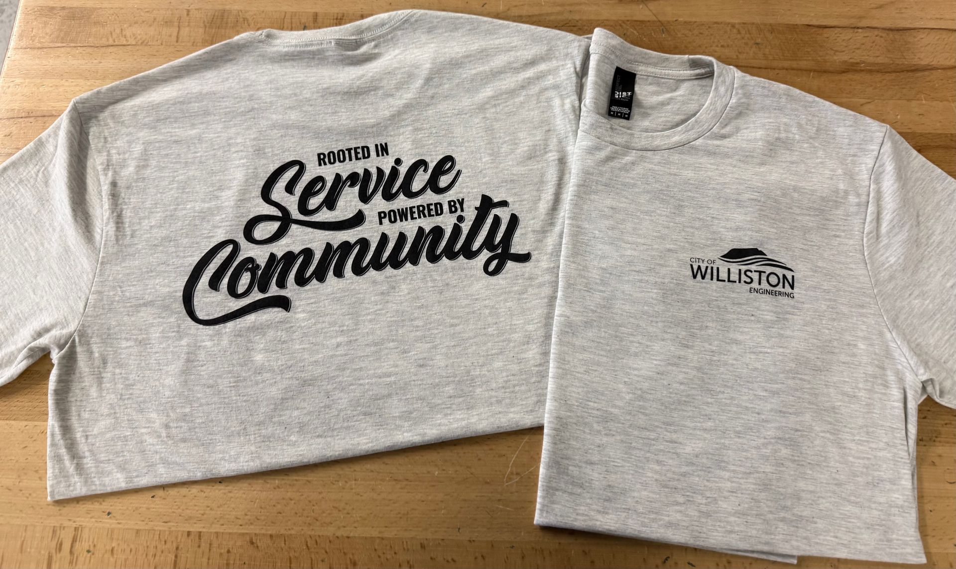Gray T-shirt with “Service Community” text and a small Willston logo