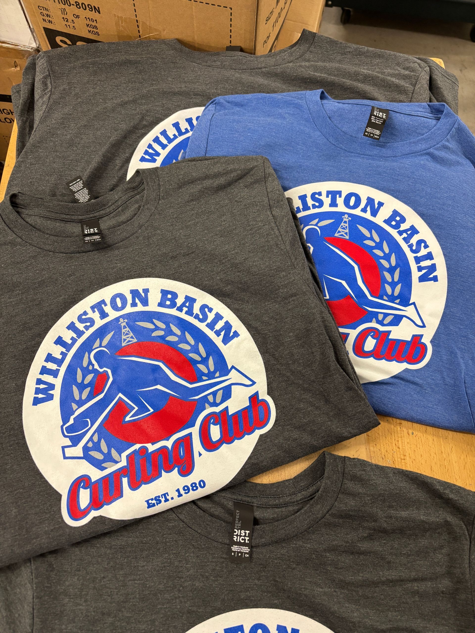 Gray fishing club T-shirts with a red fish logo and blue-white Hamilton Basin Fishing Club text.