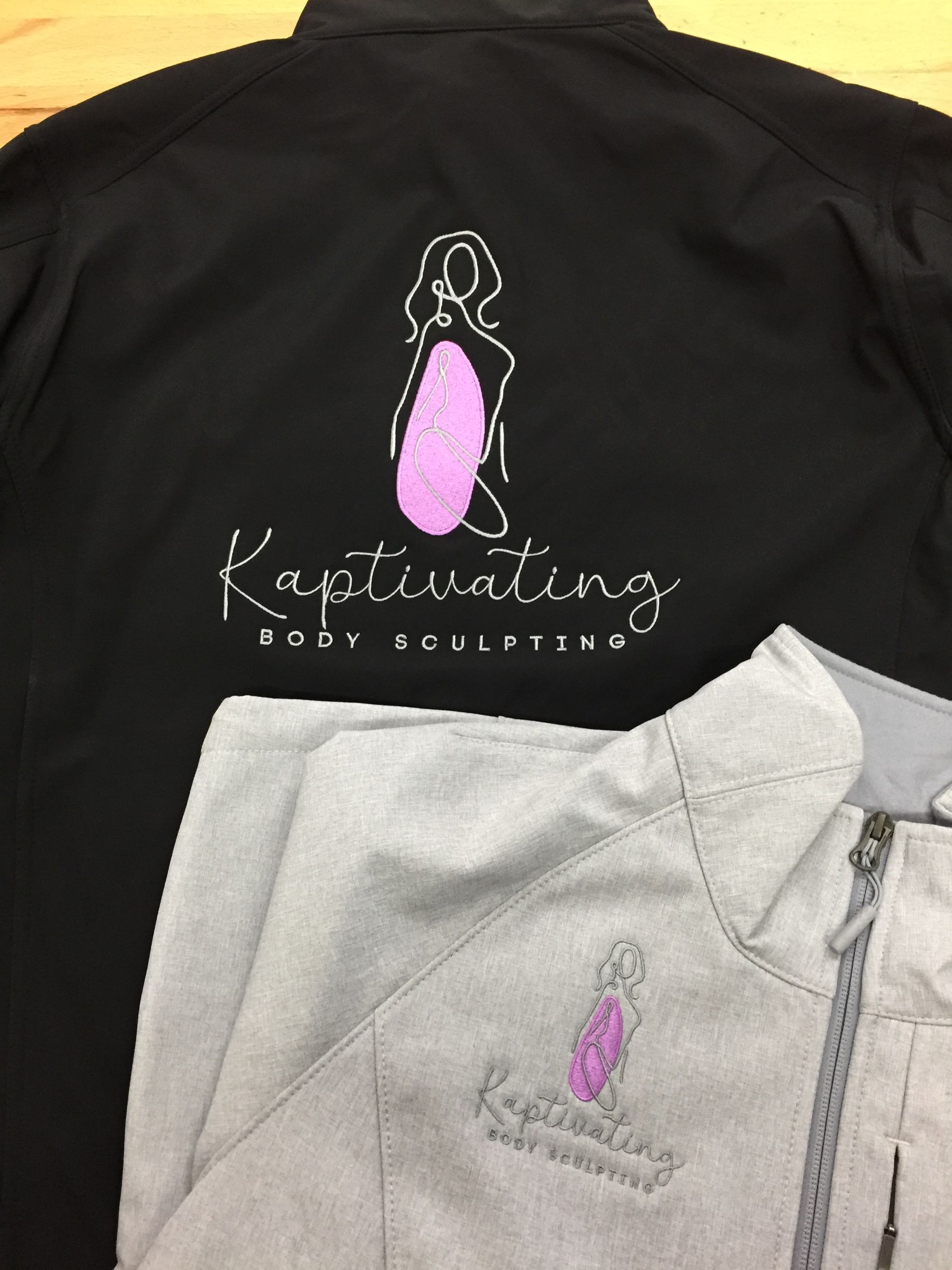 Black and gray apparel with pink logo and “Captivating” text on shirts and hoodie