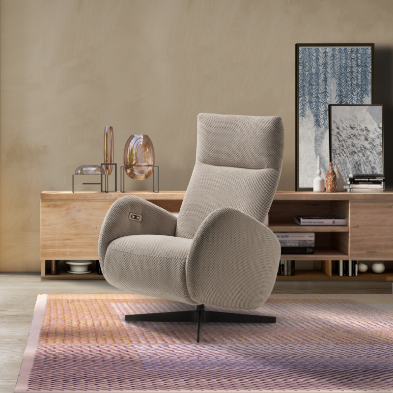 Poltrona reclinabile beige nel soggiorno, mobile in legno e opere d'arte sullo sfondo.